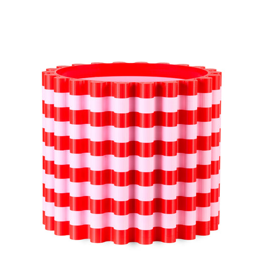 Red and white striped cylindrical flowerpoton a white background