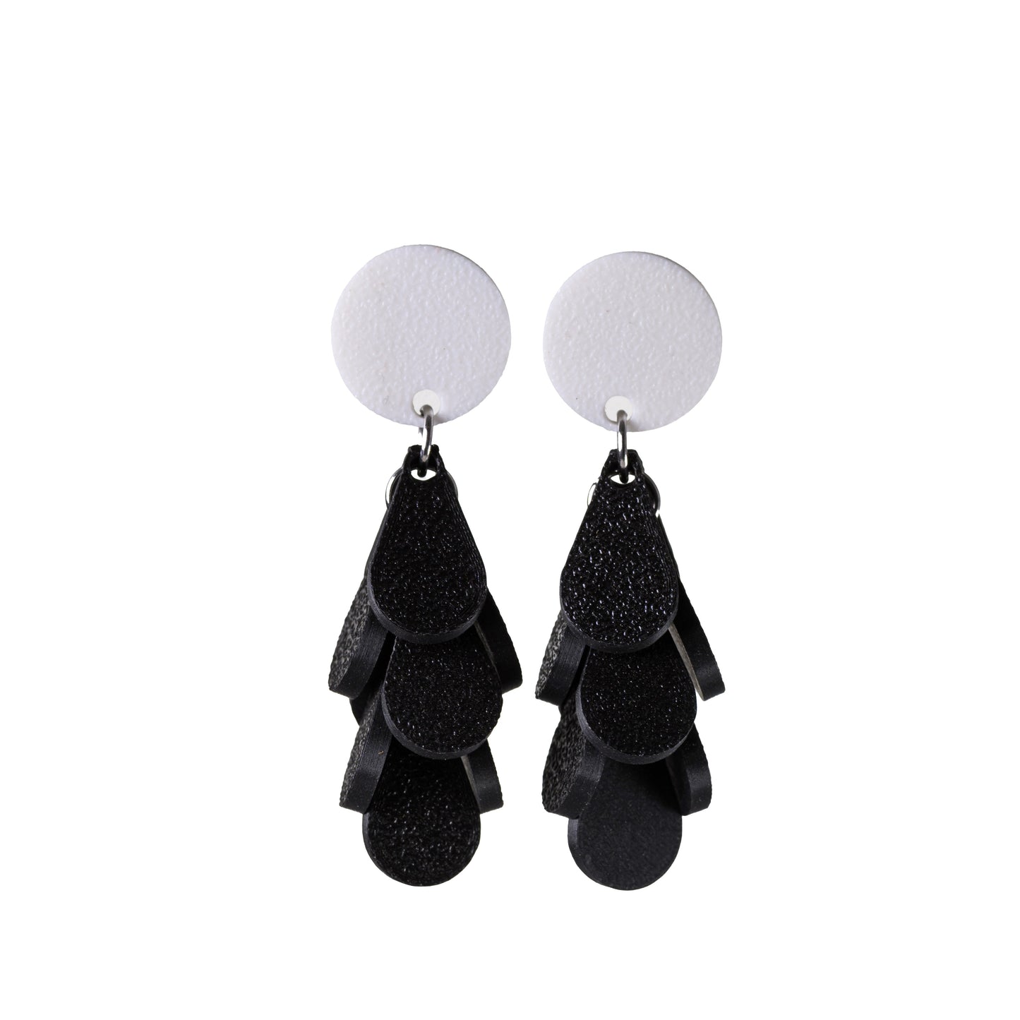 Black tiered earrings with white round tops on a white background